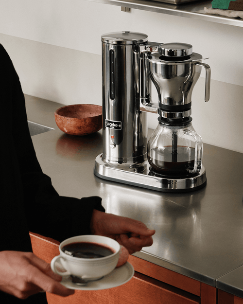 Aarke Coffee Maker in stainless steel brewing filter coffee into a glass carafe