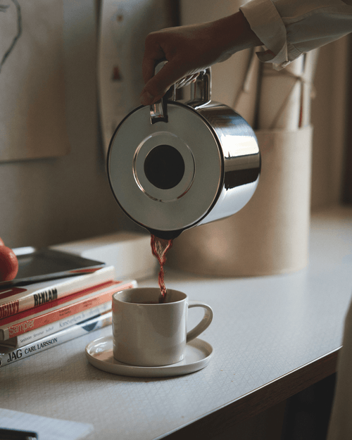 Freshly brewed filter coffee being poured from the Aarke Thermal Jug, a vacuum-insulated stainless steel coffee jug designed to keep coffee hot for hours.