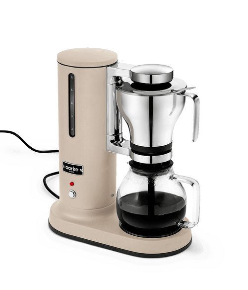 Aarke sand finish automatic pour-over coffee maker brewing fresh drip coffee into glass carafe – Scandinavian kitchen coffee machine.