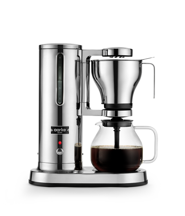 Front view of Aarke Coffee Maker with stainless steel finish and full glass carafe.