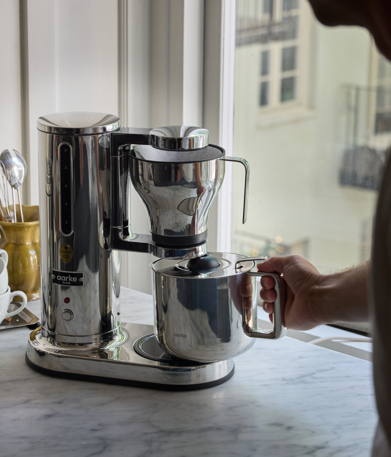 Aarke stainless steel coffee maker brewing coffee directly into the matching Aarke thermal jug.