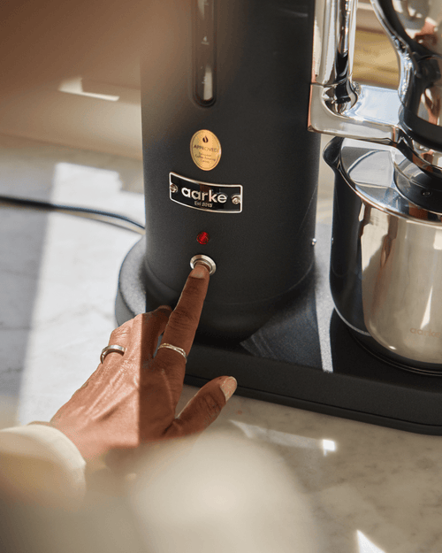 Close-up of the Aarke Coffee Maker in Matte Black showing the power button, indicator light and stainless steel Thermal Jug.