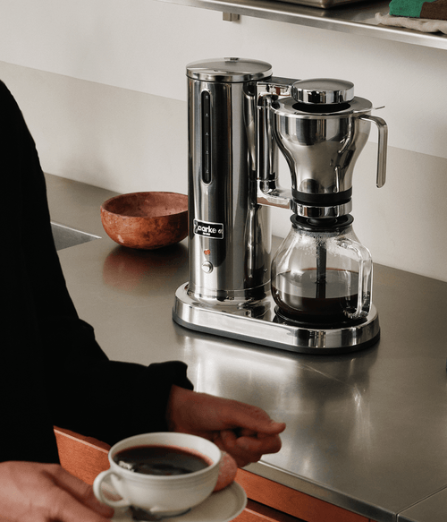 Aarke Coffee Maker in stainless steel brewing filter coffee into a glass carafe