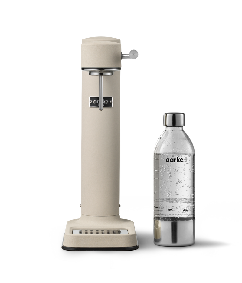 Aarke Carbonator 3 in Sand displayed with  a PET water bottle.