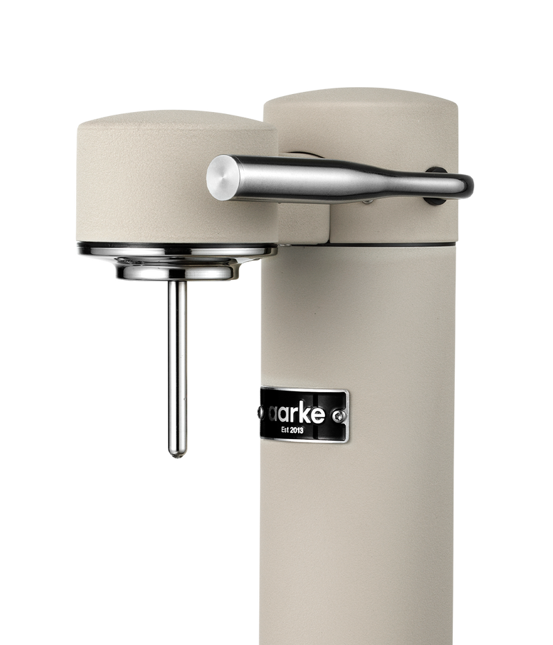 Close-up of the Aarke Carbonator 3 in Sand, highlighting the carbonation lever and nozzle.