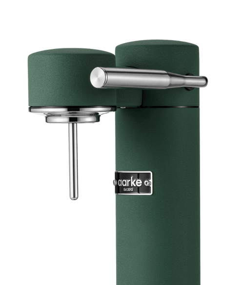 Close-up of the Aarke Carbonator 3 in Heritage Green showing its textured finish, stainless steel carbonation lever, and Aarke logo.