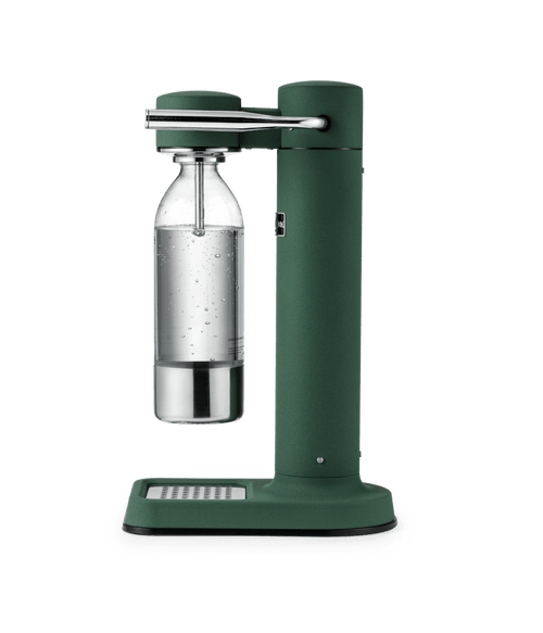 Aarke Carbonator 3 in Heritage Green with a stainless steel and glass bottle filled with sparkling water.