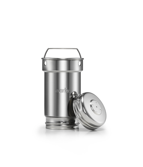 Close-up of Aarke’s stainless steel filter cartridge with the lid removed and placed beside it.
